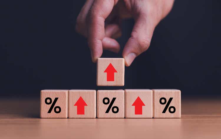 Interest rate financial and mortgage rates concept. Wooden blocks with Icon percentage symbol and arrow pointing up. The economy is improving.