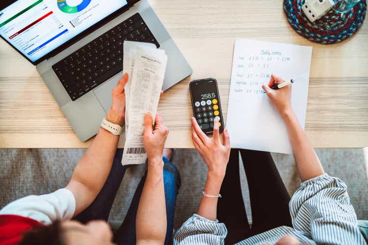 Direct above shot of Asian mom and daughter learning finance together at home