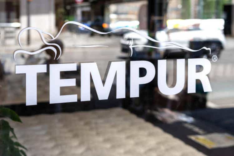 Sunlit window display of Tempur, a mattress brand renowned for its comfort and sleep quality, in a cityscape.