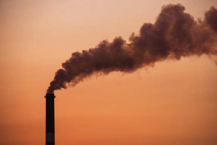 Smoke bellowing from a smoke stack at a furnace in Mount Isa photographed at sunset, Queensland, Australia