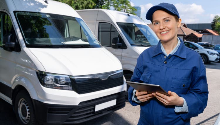 Manager with a digital tablet next to vans.