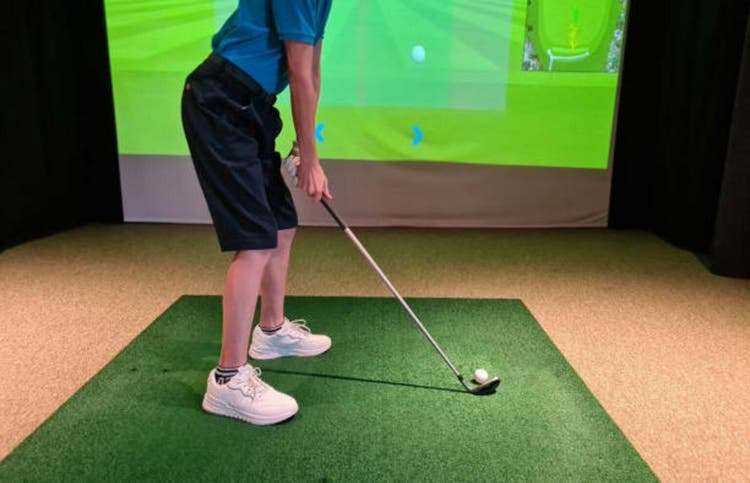 Golfer Practicing Swing on Indoor Golf Simulator