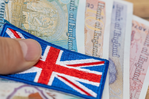 Great britain money, great britain flag and british pounds held in hand, close up, financial business concept, uk currency