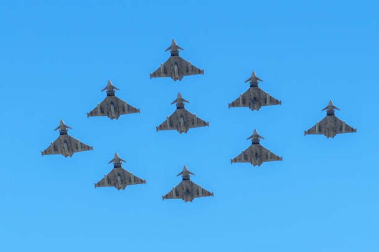 Many Eurofighter Typhoon fighter jets flying in formation against a bright blue sky. Spanish Air Force