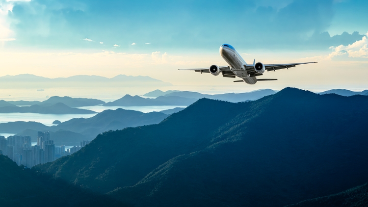 Commercial airliner flying over mountains. Travel background