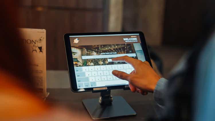 Friends Using Self Check-In on tablet at Hostel