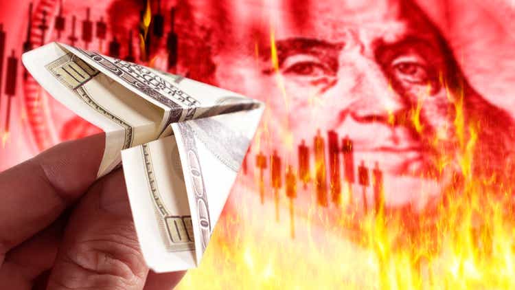 USD money on fire. Airplane from dollar bill. Hand with USD banknote. Portrait of Franklin on fire. US currency high inflation concept. Metaphor of burning USD money due to inflation.