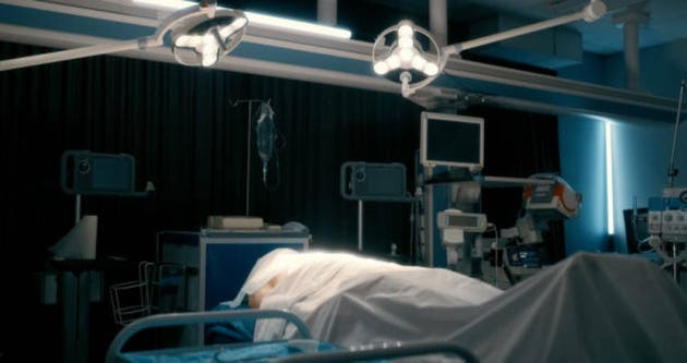 Dark, death and body of person in hospital on bed for healthcare, medical or tragic accident. Eternity, mortality and rest with cadaver of patient in clinic for afterlife, emergency or mistake