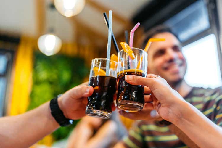 Group Of Friends Cheering With Their Drinks In A Café Indoors