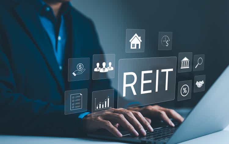 REIT, Real Estate Investment Trust Concept. A businessman works on a laptop with icons representing Real Estate Investment Trust, various aspects of real estate investments, and financial management.