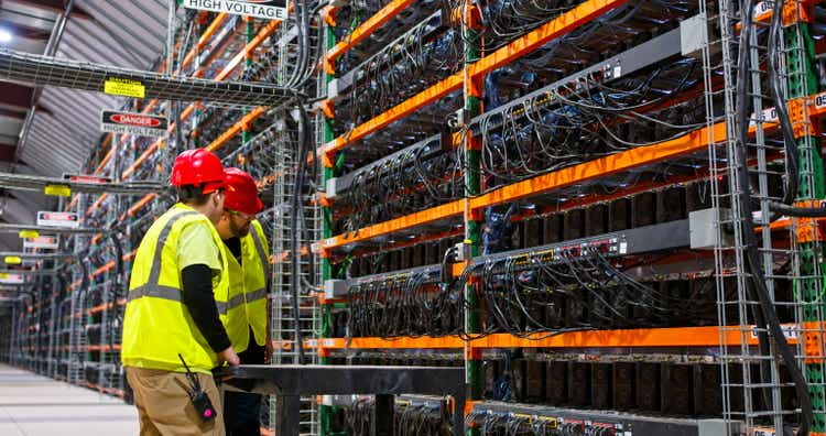 Two IT Technicians Inspecting Equipment in Huge Data Center