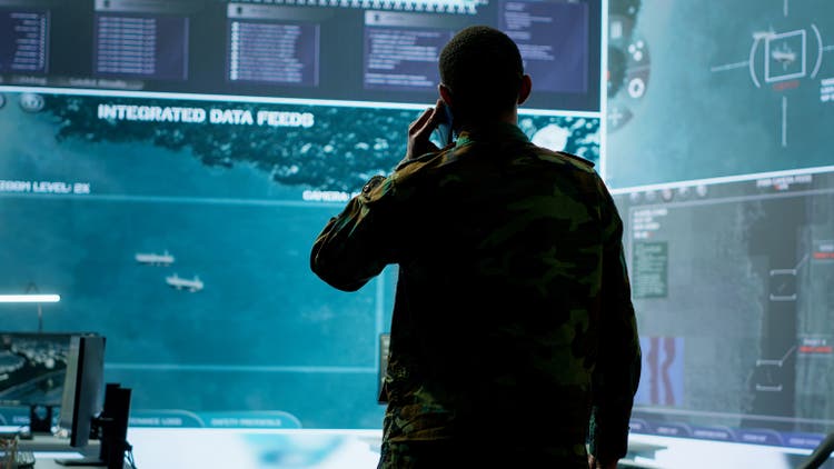Military man answers phone call in a mission control center
