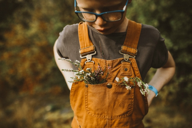 Boywith wildflowers in his dungarees