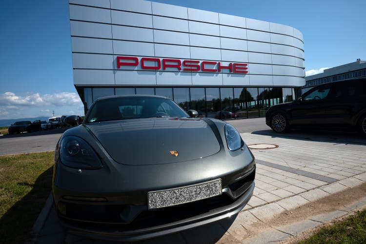 a Porsche car parked in front of a dealer