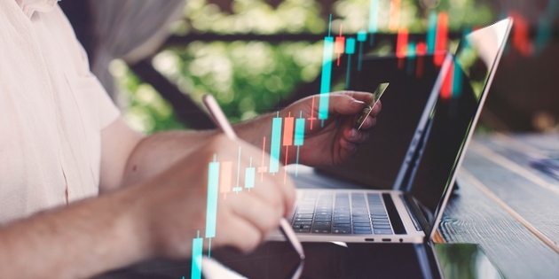 Budget and financial planning concept. Businessman analyzing investment charts with calculator and laptop. Double exposure.