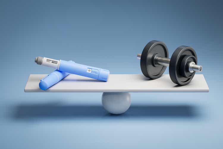 Two dosing pens of a fictitious semaglutide drug (GLP-1) on a scale facing a dumbbell. Concept for alternative ways to loose weight.