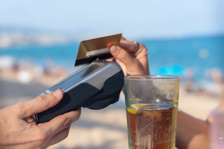 Unrecognizable man customer paying with contactless credit card in a restaurant.