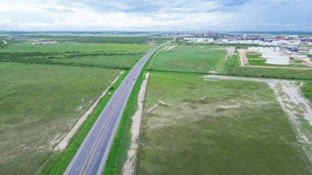 Texas 48 Brownsville-Port Isabel Highway near large fuel terminal row of liquids storage capacity tanks for streamlined oil, gasoline, diesel, jet fuel, petroleum products, ship harbor, aerial