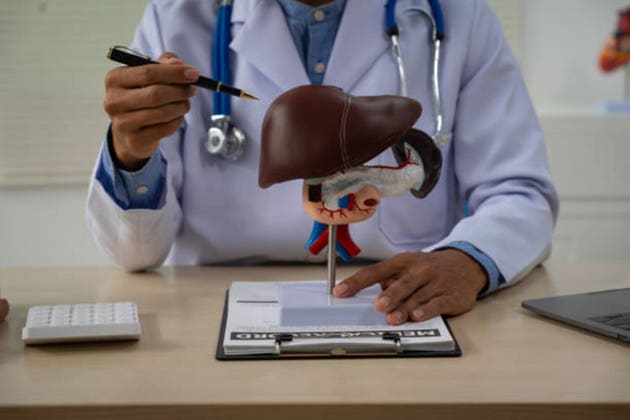 A male doctor sits at a table in a liver disease clinic, giving online advice on hepatitis A, D, E, pancreatitis, fatty liver, cirrhosis, liver cancer, and pancreatic cancer.