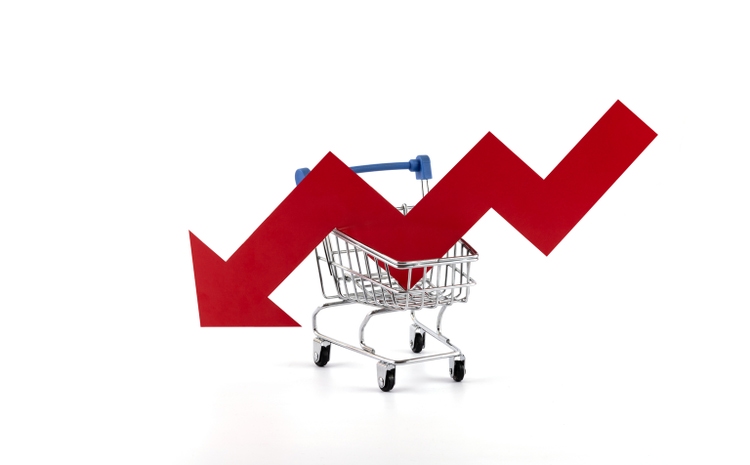 Red arrow financial graph falling in supermarket shopping cart on white background