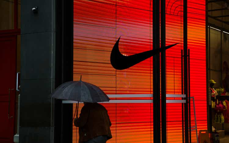 Man walking in front of a NIKE retail store at night