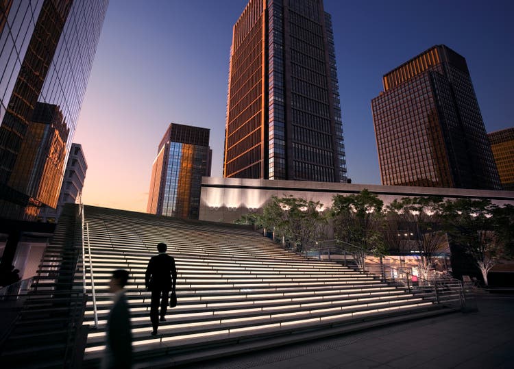 Businessmen arriving at modern business district at dawn
