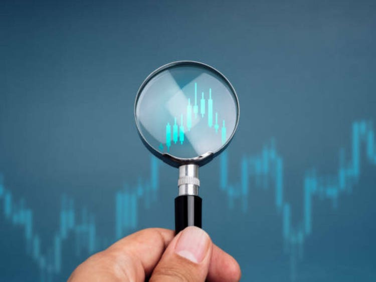 Investing in investment, research and analysis in the economy market, stock trading strategy, goal and concept of success. The growing graph, the candle graph in the glass lens amplifier on the blue background.