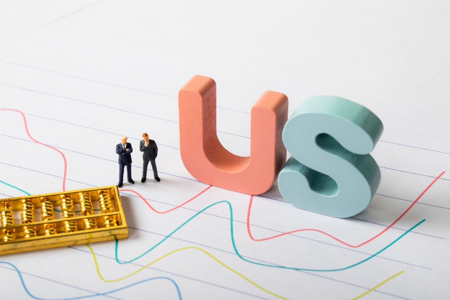 Two male businessmen stand next to the letter US, observing the US stock index - a miniature landscape, financial and stock concepts