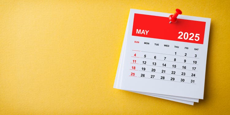 White Sticky Note With 2025 May Calendar And Red Push Pin On Blue Background