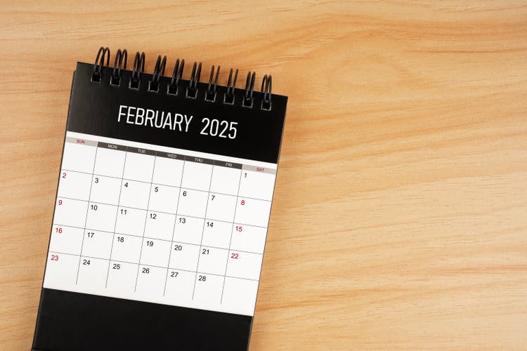 February desk calendar for 2025 year on wooden floor.