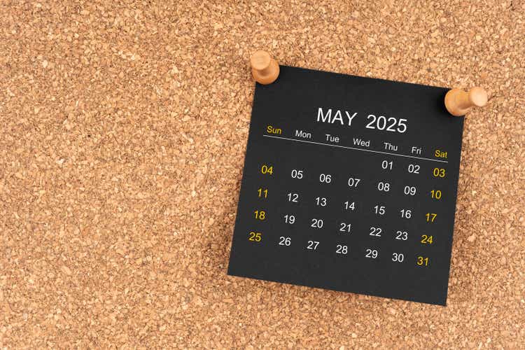 Black calendar sheet for May 2025 with thumbtack on wooden board, Position with copy space.