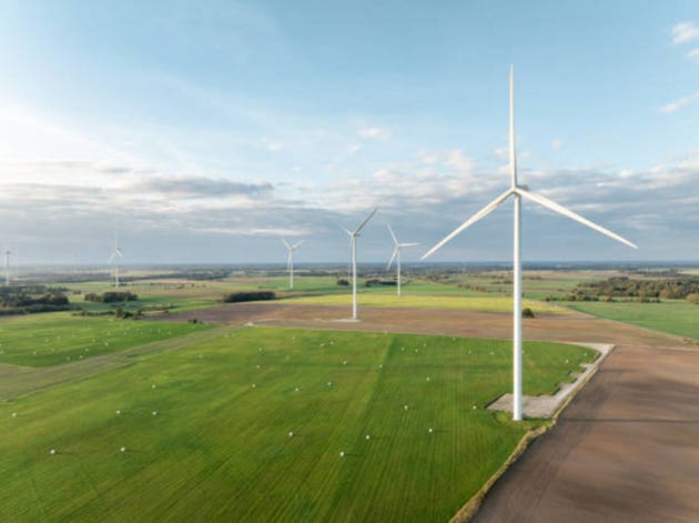 Wind Turbine Wind Park. Aerial Drone View. Aerial Drone Point of View, with more wind turbines in the distance. Sustainable synergy of onshore and farming. Beautiful Landscape. Golden Hour