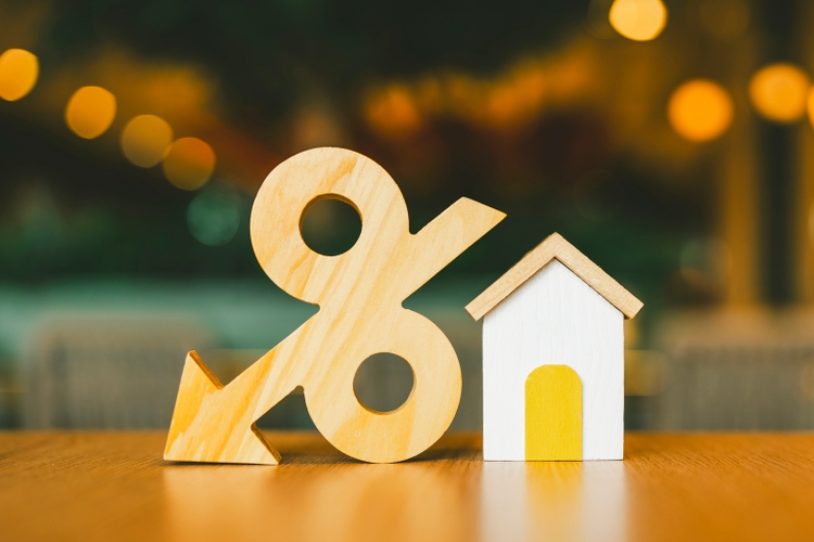 Percentage and house symbol on wood table. Concepts of home interest, real estate, investing in inflation.