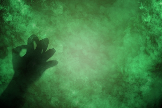 Shade of witch hands on dark background. The hand appearing to be devil, evil, satan, or monster hands