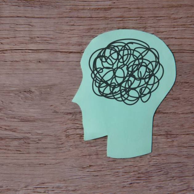 Paper cutout of a human head with tangled mess of black lines.