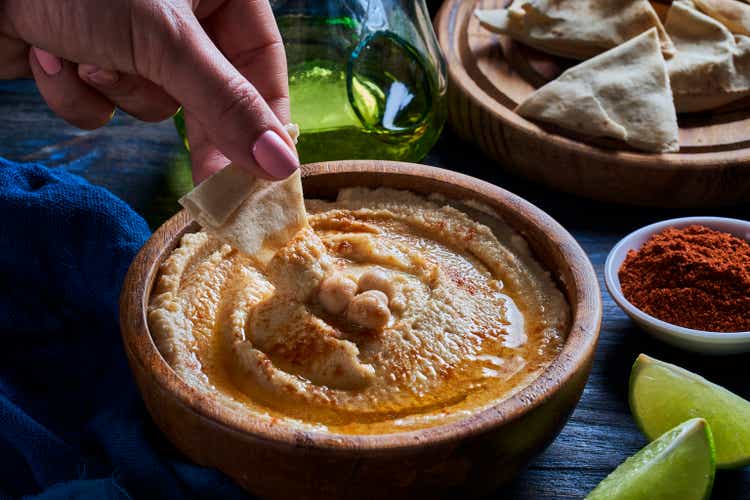 Chickpea hummus in a bowl garnished with paprika and olive oil.