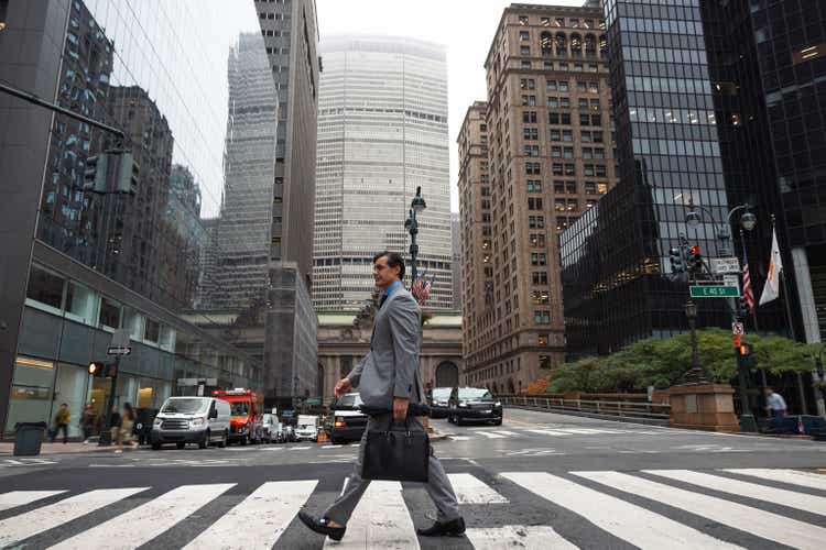 Businessman crossing Park Ave in New York City