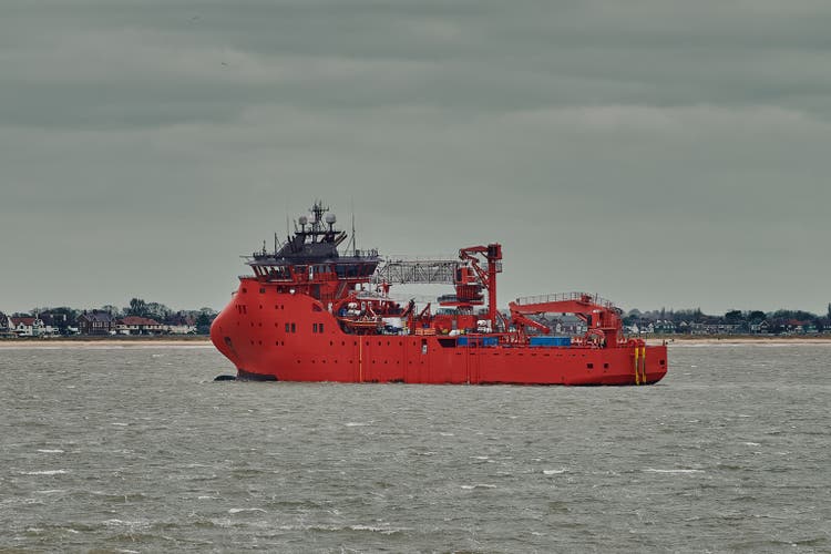Offshore support vessel sailing in port.