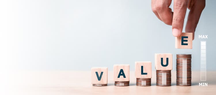 Value concept. VALUE wording on increasing wooden block on coins stacking.