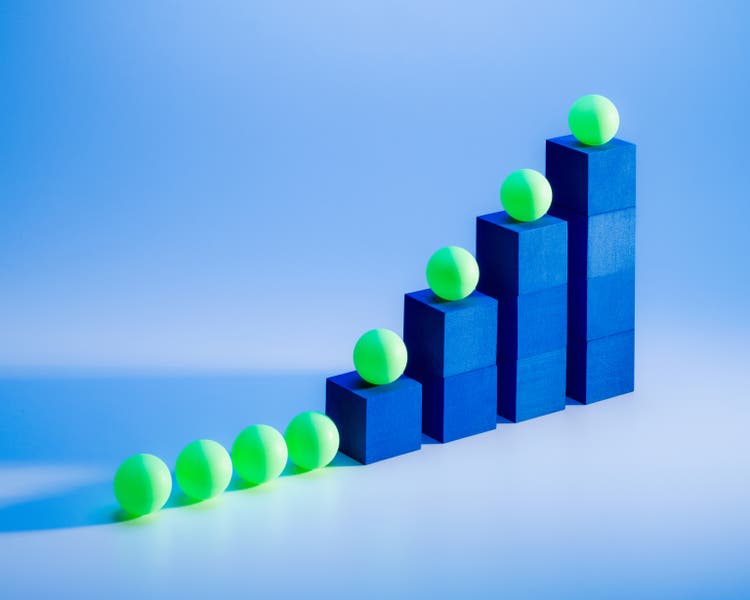 Bar graph growth concept blue blocks and green balls