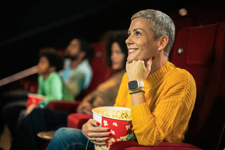 Beautiful woman smiling while watching a movie at the cinema