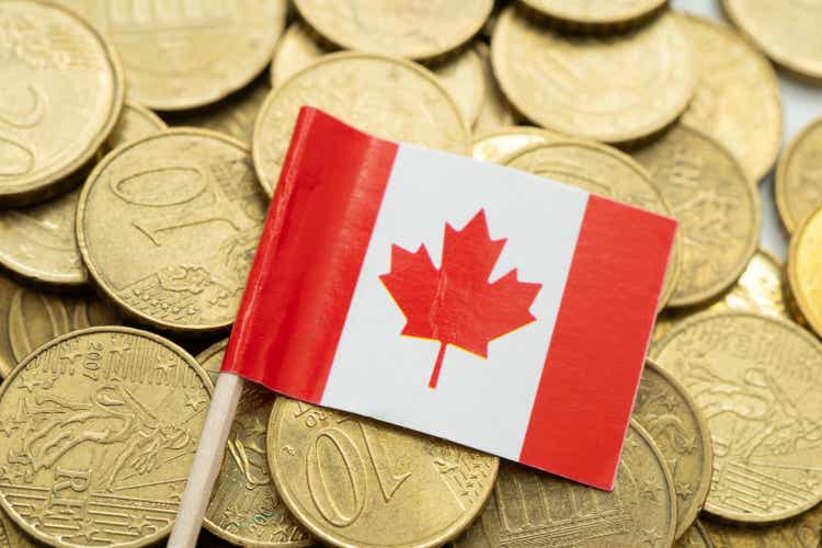 Canada flag on coin and banknote money, finance trading investment business currency concept.