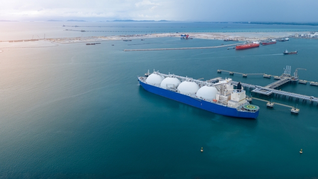 LNG (Liquefied natural gas) tanker anchored in Gas terminal gas tanks for storage. Oil Crude Gas Tanker Ship. LPG at Tanker Bay Petroleum Chemical or Methane freighter export import transportation