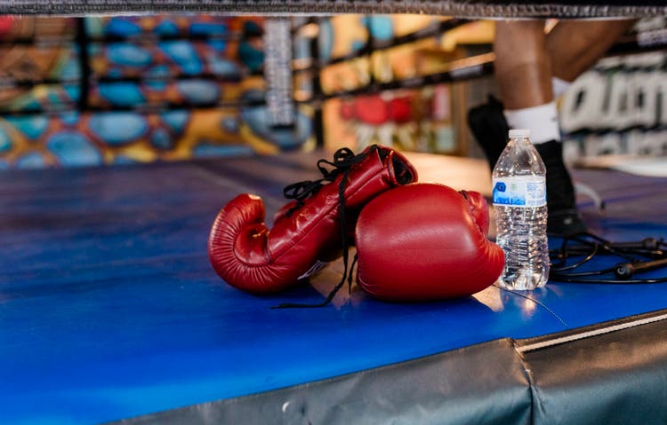 Boxing Gloves, Water Bottle, and Jump Rope on the Ring Floor
