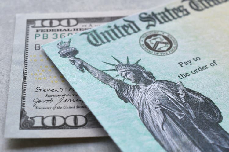 Cheque del Tesoro del Gobierno de los Estados Unidos con billete de cien dólares.