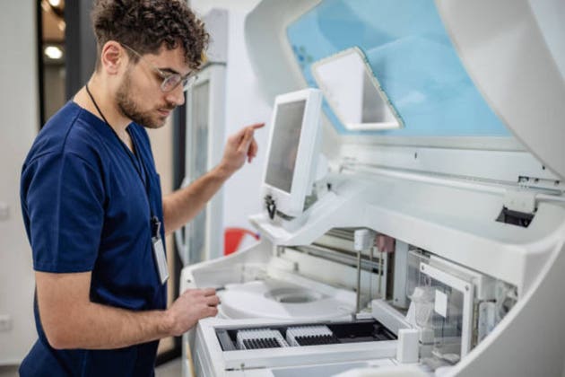 Lab technician using advanced medical equipment carefully