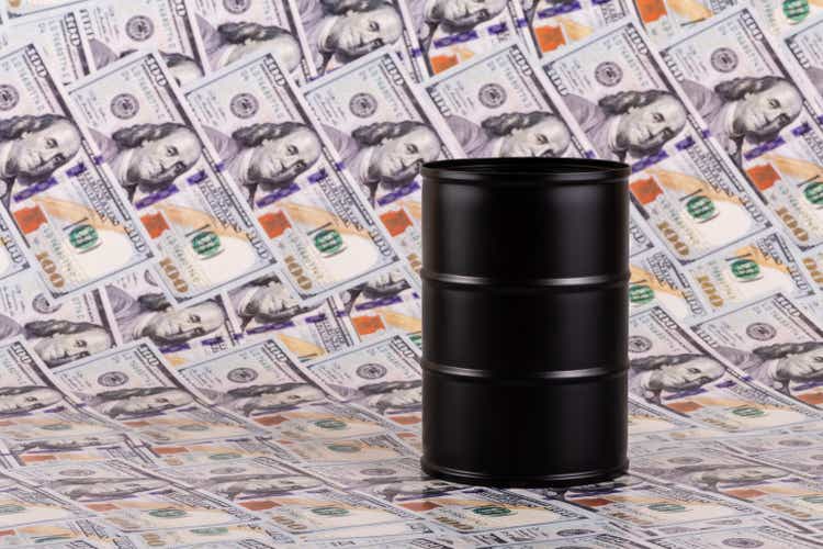 Metal oil barrel with 100 US dollar bills in the background