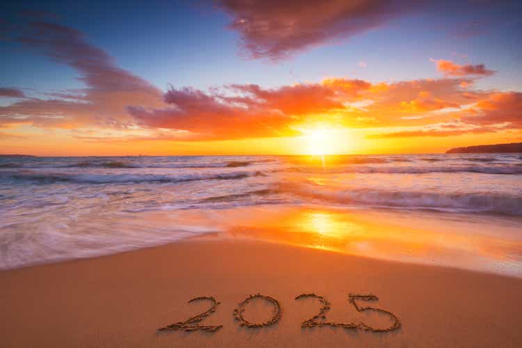 Happy New Year 2025 concept, text lettering on the beach sand at sunrise.