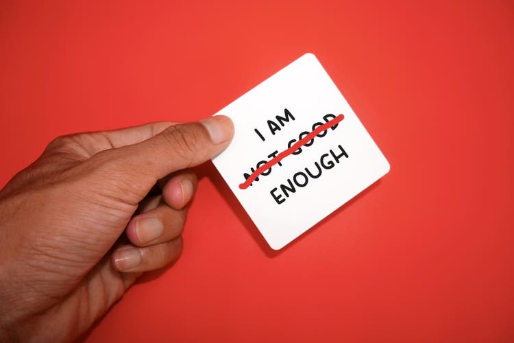 text I AM NOT GOOD ENOUGH with a red strikethrough on NOT GOOD, mental health concept, self-confidence and change negative inner