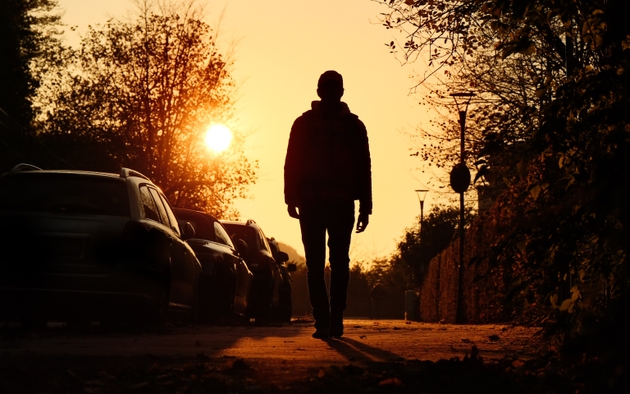 Silhouette of a man walking in the town, tranquil backlit scene